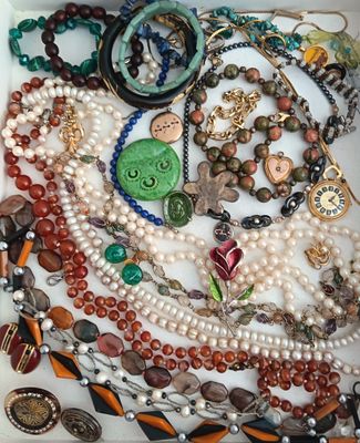 une boîte blanche remplie d'un assortiment de perles et de bijoux