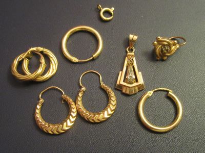 a lot of gold rings and earrings on a table