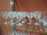 many wine glasses on a glass shelf in a store