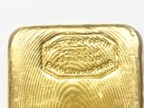 a close up of a gold bar on a white surface