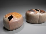 two small vases with holes in them on a table