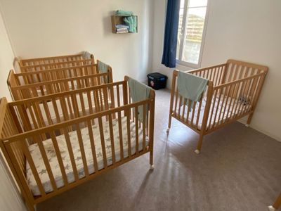 deux lits bébé qui se trouvent dans une petite chambre