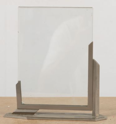 a mirror sitting on a wooden table with a white background