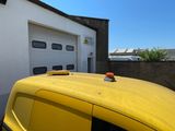 a yellow van parked in front of a garage door