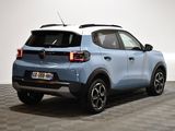 the rear end of a blue and white car parked in a room