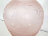 a pink vase sitting on top of a white table