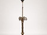 an antique brass floor lamp with a glass shade on top of it