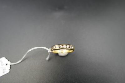 a gold wedding ring with diamonds on a black surface