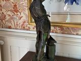 a statue of a man holding a bird on top of a table