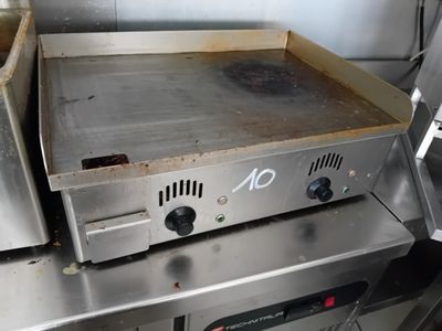 plan de travail en acier inoxydable équipé d'une plaque de cuisson, dans une cuisine professionnelle