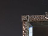 a mirror with a bird sitting on top of it