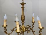 a gold chandelier with five lights hanging from it