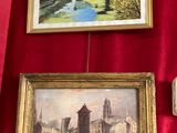 deux tableaux encadrés représentant une rivière et un pont, accrochés à un mur rouge