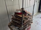 un chariot rempli de cartons et des cartons par terre dans une pièce