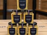 a stack of six jars of mustard sitting on top of a cardboard box