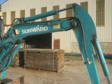 a blue excavator that is parked in front of a building