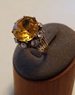 une image représentant une bague ornée d'une grosse citrine entourée de diamants