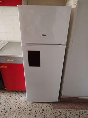 un réfrigérateur blanc dans une cuisine aux placards rouges