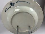 a white plate with blue flowers on it on a stand