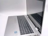 a silver laptop computer sitting on a white surface