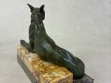 statue of a cat sitting on a marble block on a white background