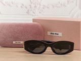 sunglasses and case on a table with a pink box in the background