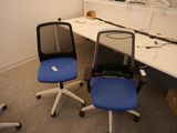 deux chaises de bureau bleues placées devant un bureau blanc