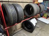 four tires stacked on a red rack in a garage