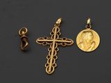 deux croix dorées et une pièce de monnaie sur fond noir