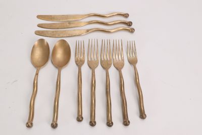 five forks, two spoons, and a knife on a table