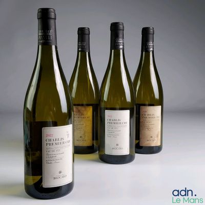 trois bouteilles de vin blanc sont alignées sur une table