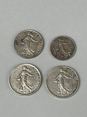quatre types différents de pièces d'argent sur une surface blanche