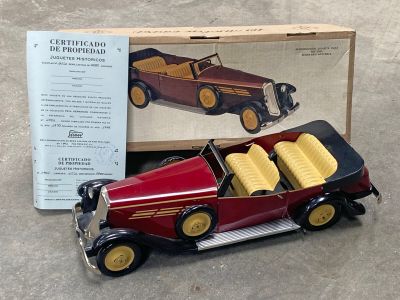 une petite voiture rouge avec une boîte par terre