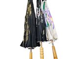 three umbrellas that are hanging on a wooden pole
