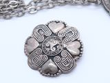 an image of a silver necklace with a coin on a chain
