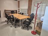 a room with a table, chairs, and shelves in it
