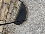 a black umbrella that is on the ground near a stone wall