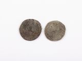 two silver coins, one of which is a man and the other of which is a woman
