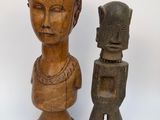 deux statues en bois représentant une femme et un homme sur fond blanc