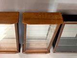 three glass display cases sitting next to each other on a table