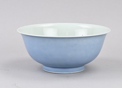 bol en porcelaine bleue et blanche posé sur un fond gris