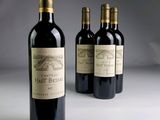 three bottles of red wine sitting next to each other on a table