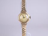 an image of a woman ' s wrist watch sitting on a clear stand