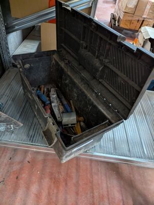 a metal box with tools inside of it on the floor