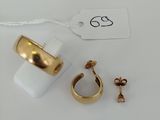 two gold rings and a pair of earrings on a white surface
