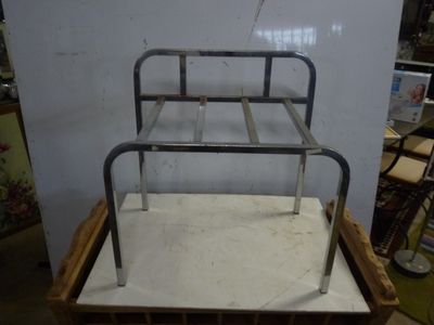 a metal bed frame sitting on top of a wooden box