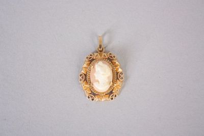 a close up of a gold pendant with a picture of a woman ' s face
