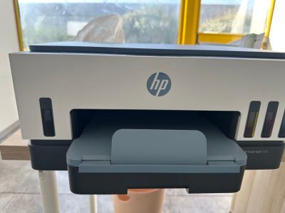 a printer sitting on top of a stand in front of a window
