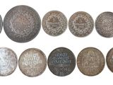 plusieurs types de pièces de monnaie sont présentés sur une surface blanche