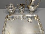 a silver tray with a silver tea set on it